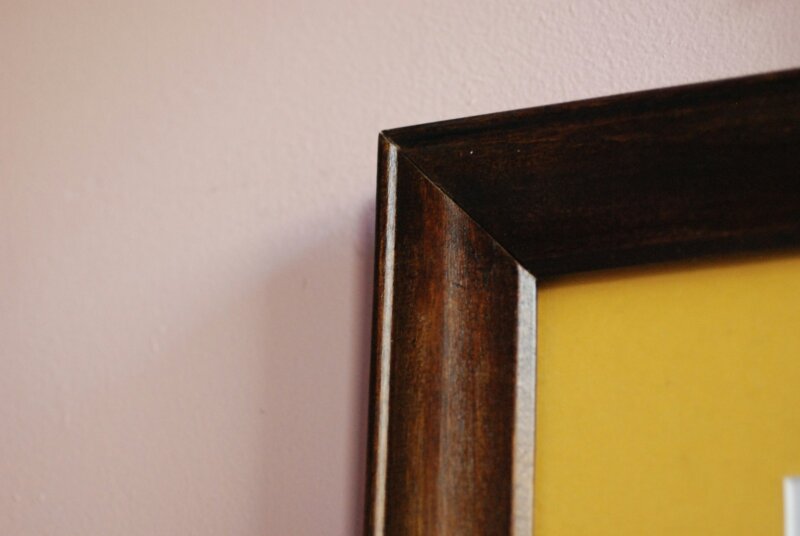 a picture frame hanging on a pink wall