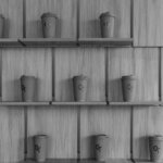 a black and white photo of coffee cups on shelves
